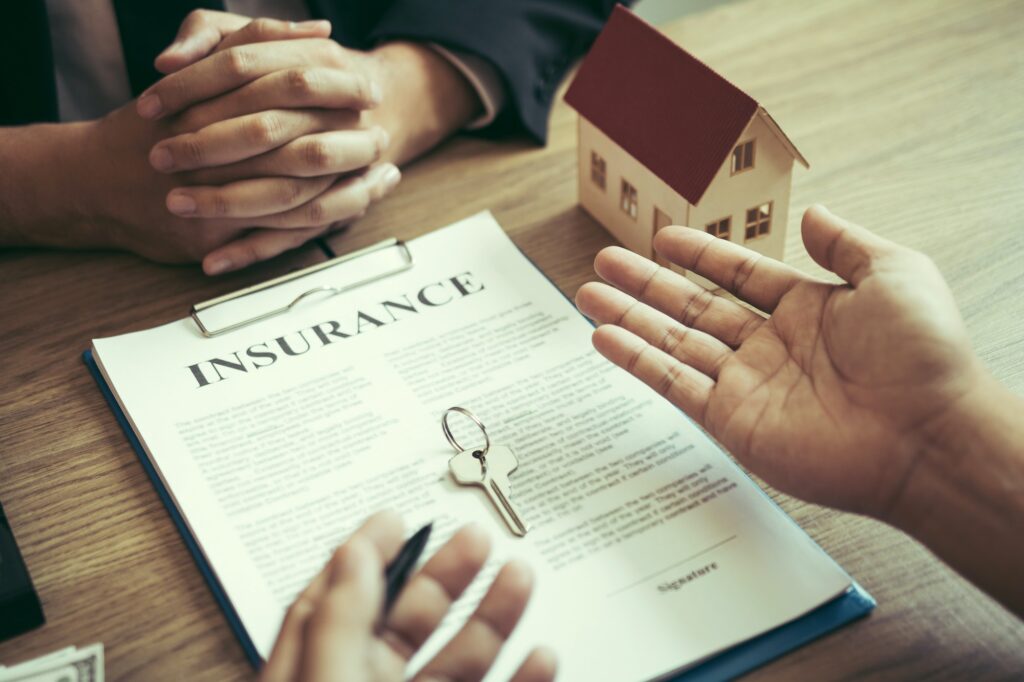 Customers buying houses are negotiating about the cost of home insurance with agents.
