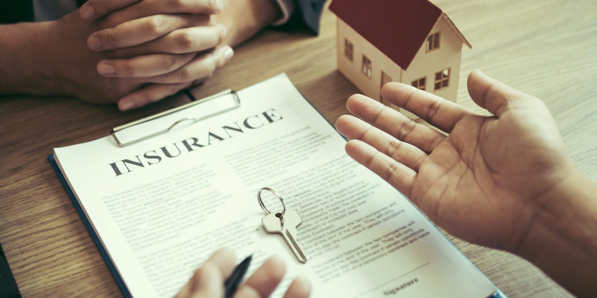 Customers buying houses are negotiating about the cost of home insurance with agents.